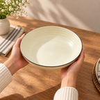 Round ceramic Cove Serving Bowl with concentric detailing in a warm ivory finish.