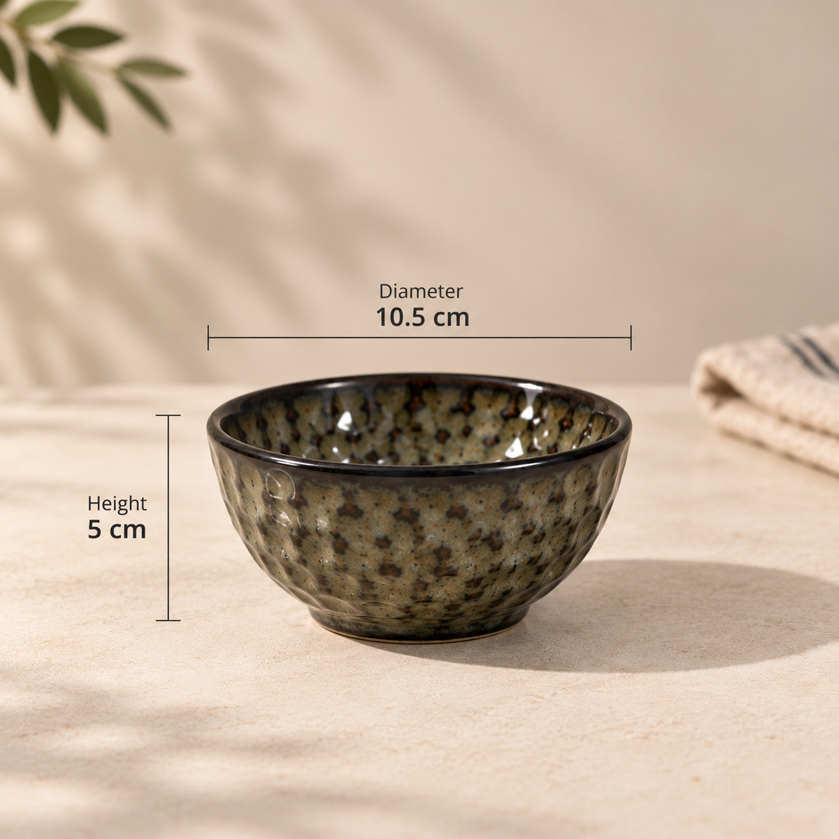 A small ceramic bowl with a textured speckled glaze in olive green, brown, and black, shown with dimension lines indicating a diameter of 10.5 cm and height of 5 cm.