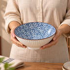Round ceramic Sakura Serving Bowl featuring a delicate blue cherry blossom-inspired floral pattern.
