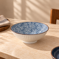 Round ceramic Sakura Serving Bowl featuring a delicate blue cherry blossom-inspired floral pattern.