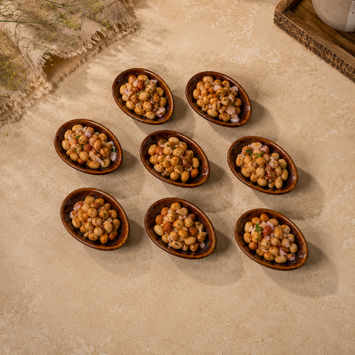 Seven Ceramic Amber Tide Petite Server filled with a chickpea salad, arranged on a beige stone surface with a rustic cloth and tray in the background.