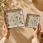 OZAY Living Blooming Buds serving platter on a textured beige background, held by hands against a warm beige backdrop with soft leaf shadows.