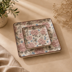 OZAY Living Peony serving platter set with a pink and blue floral pattern on a beige background, styled on a beige fabric surface with dried flowers and a potted plant.